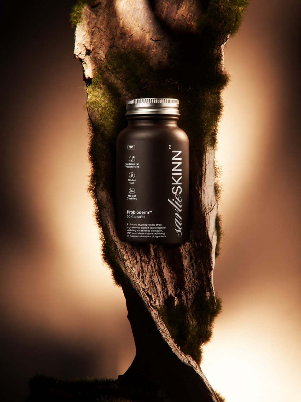 Probioderm bottle suspended against a mossy rock, warm backlight